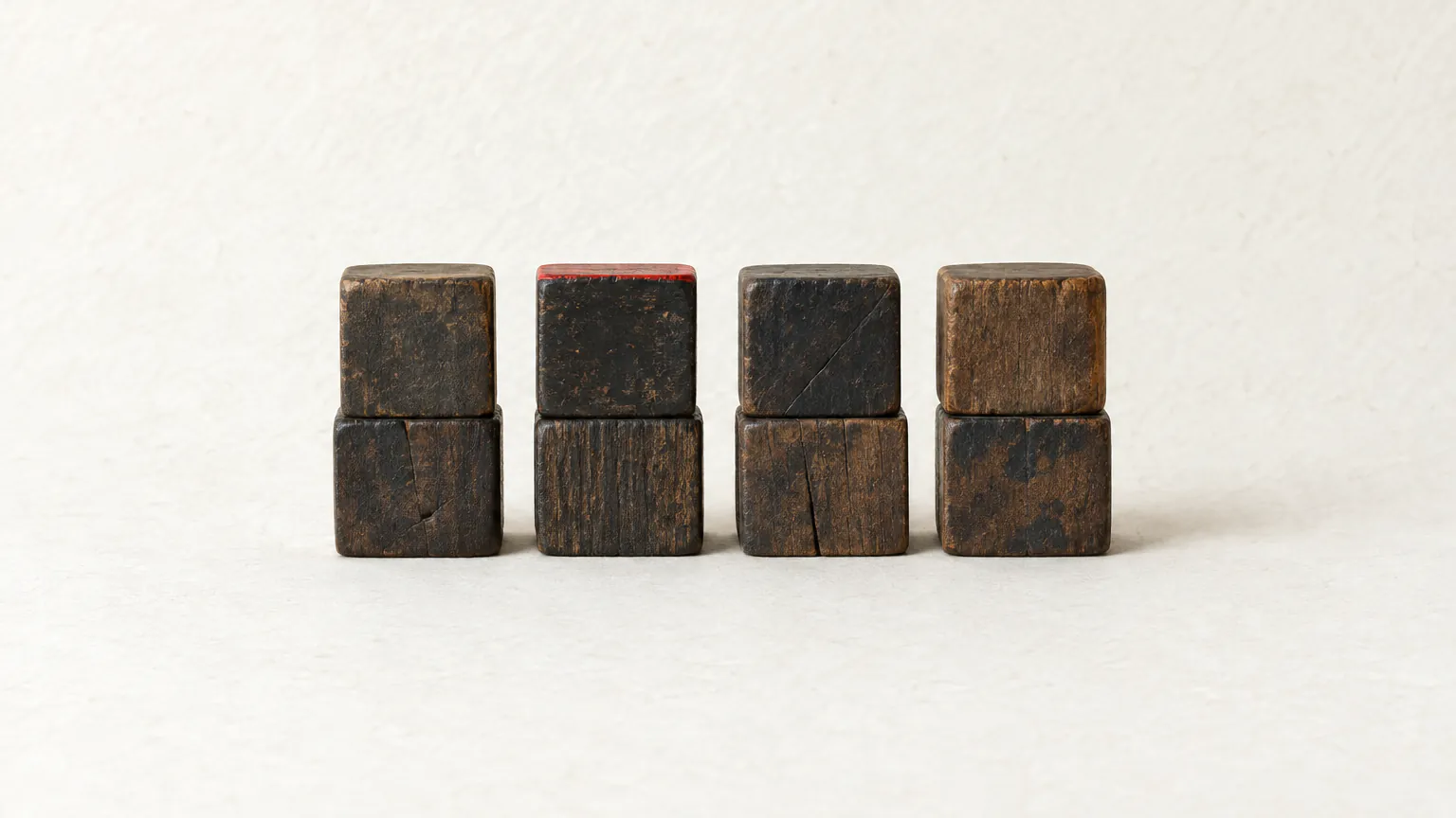 Eight dark wooden blocks in four stacks of two, one edged in red, like the four pillars of a BaZi chart